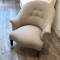 French vintage tub chair covered in Taupe linen with a buttoned back, black turned legs and brass castors. 19th C.